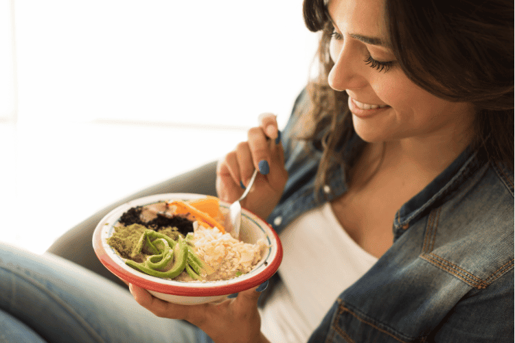 Close up of a woman eating a vegan meal at home Close-up of a woman eating a vegan meal at home
