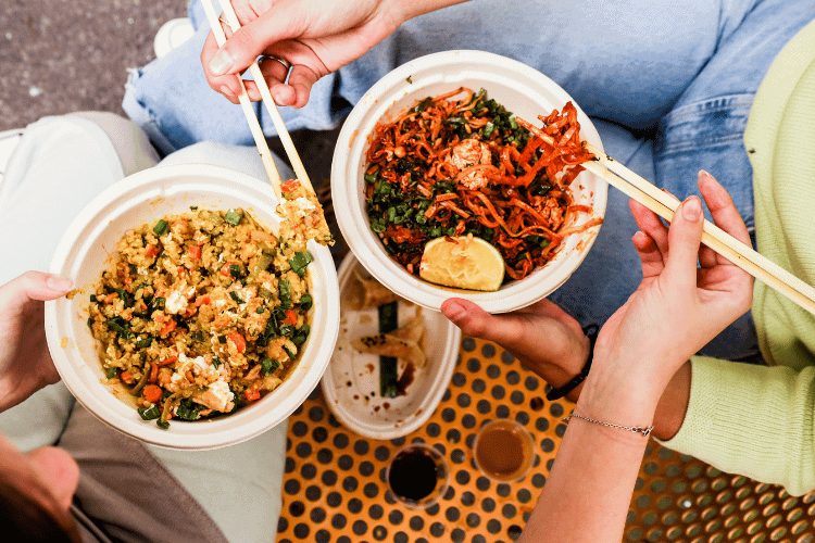 Top view of two persons eating Vegetarian meals in white bowls Top view of two persons eating Vegetarian meals in white bowls