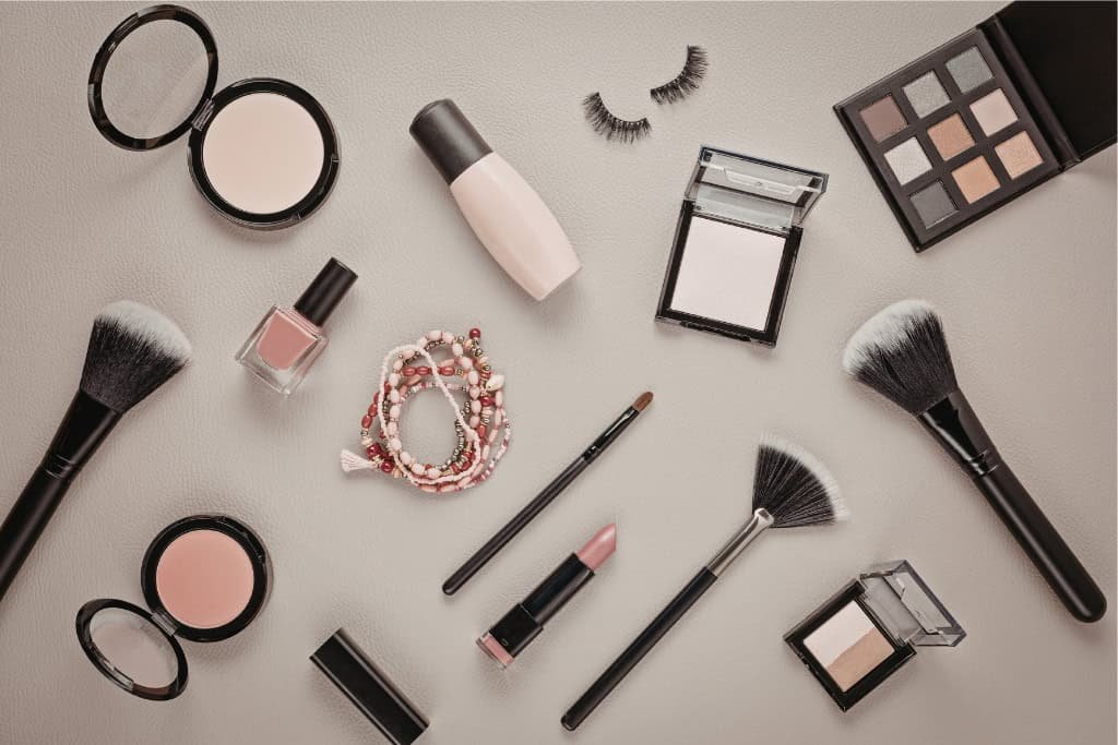 Assorted Vegan makeup products and tools arranged.